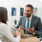 A businessman smiles as he speaks with a customer.